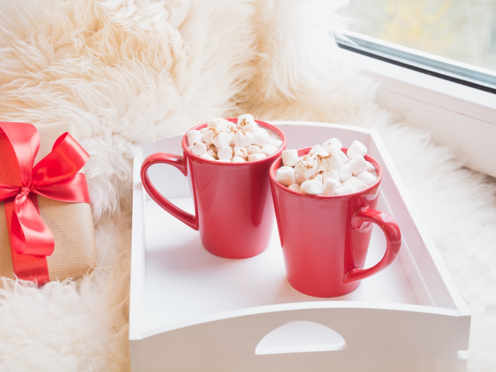 Две красные чашки с маршмеллоу у окна