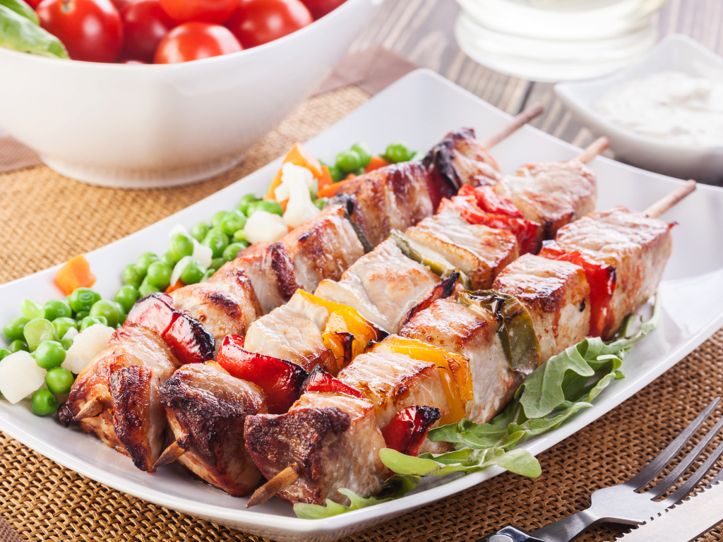 Аппетитный шашлык на тарелке с горохом