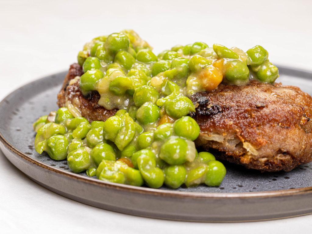 Котлета на тарелке с зеленым горошком