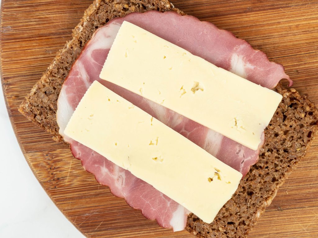 Бутерброд с ветчиной и сыром на доске 