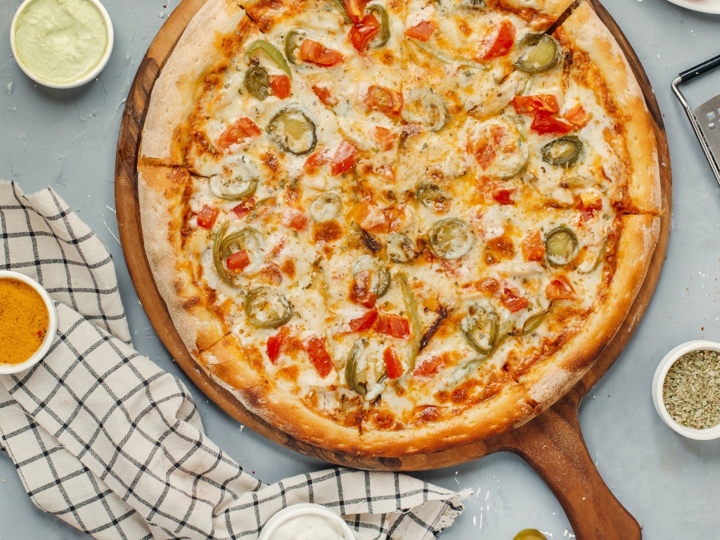 Аппетитная пицца с овощами и сыром на доске 