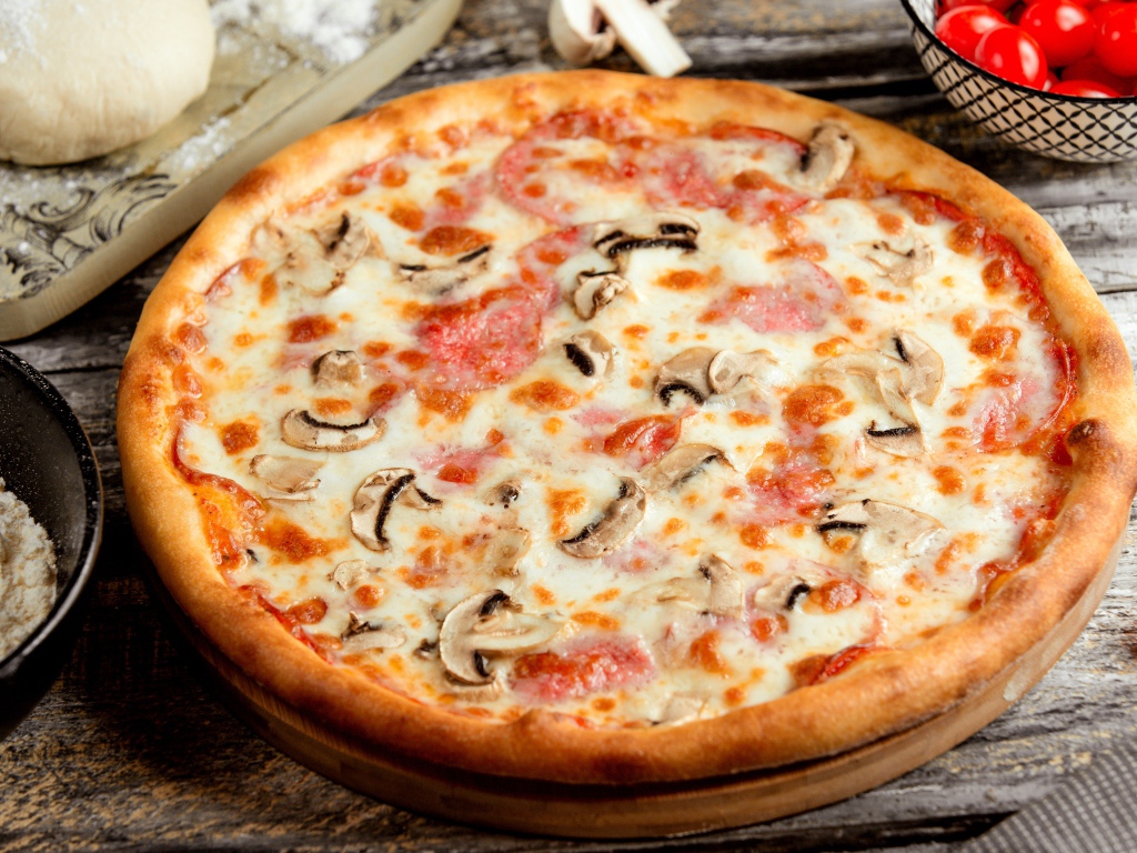 Вкусная пицца с грибами, колбасой и сыром