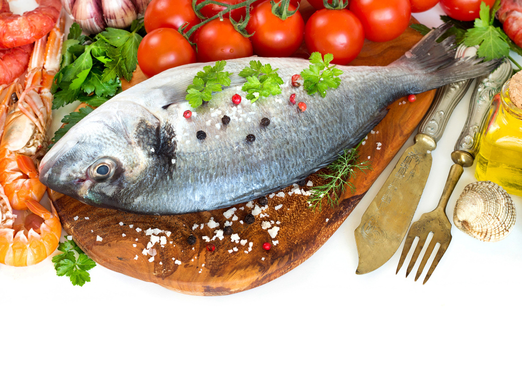 Сырая рыба на столе с маслом и помидорами 