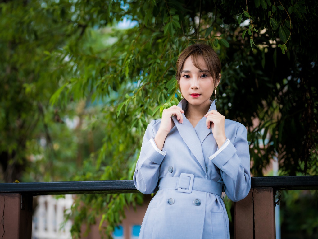 Девушка азиатка в голубом пальто в парке