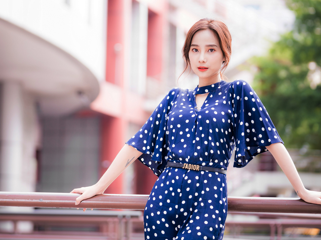 Девушка азиатка в синем платье в белый горошек