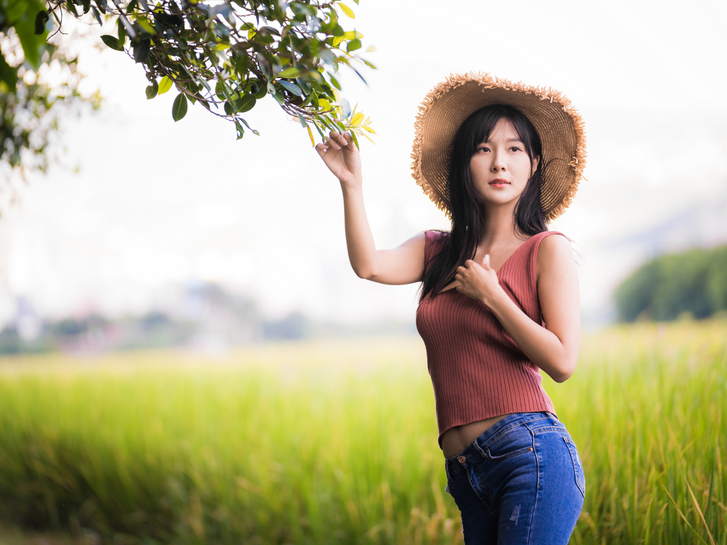 Девушка азиатка в шляпе на поле 