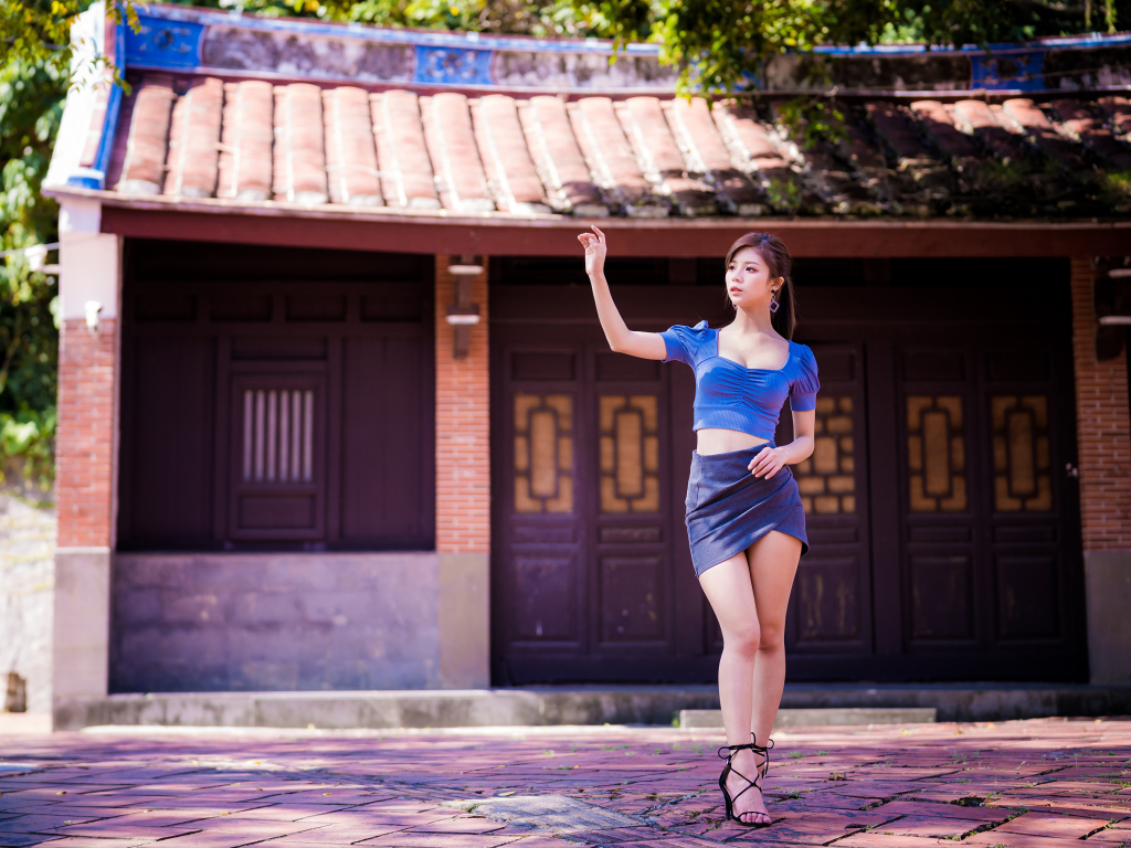 Девушка азиатка в короткой юбке у здания 