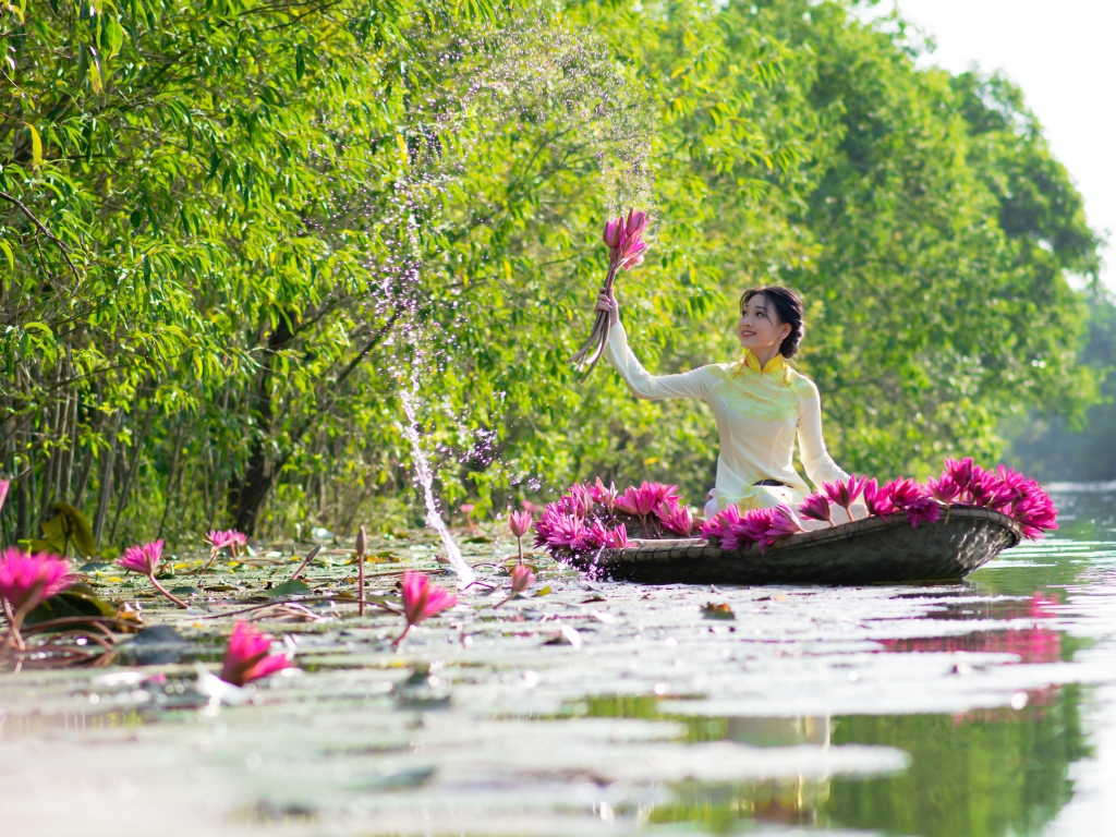 Beautiful Asian girl on a boat vomits lotus flowers in a river