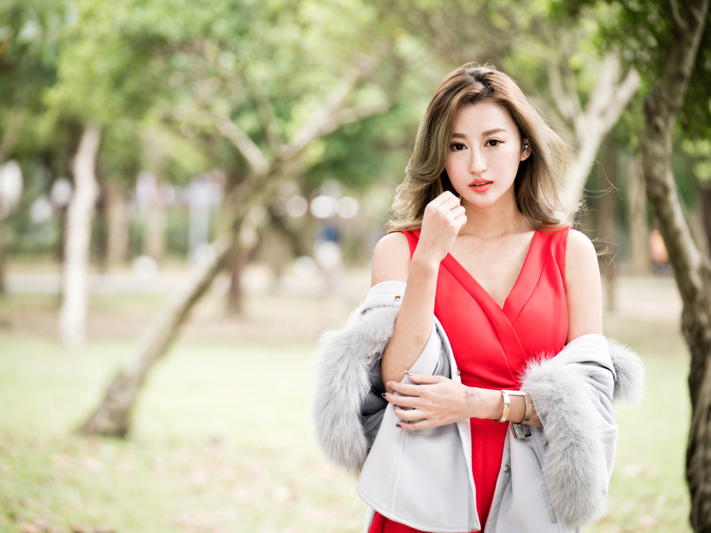 Красивая азиатка в красном платье в парке