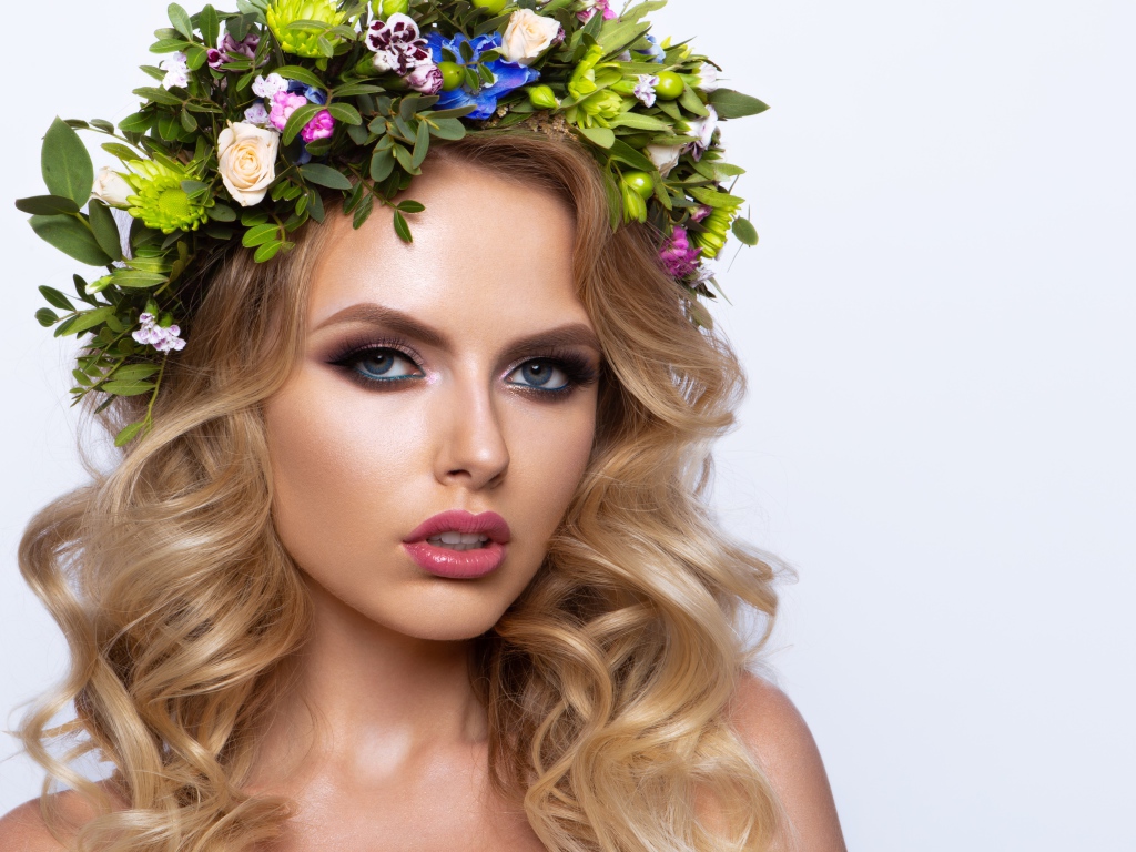 Красивая блондинка с венком из живых цветов на белом фоне