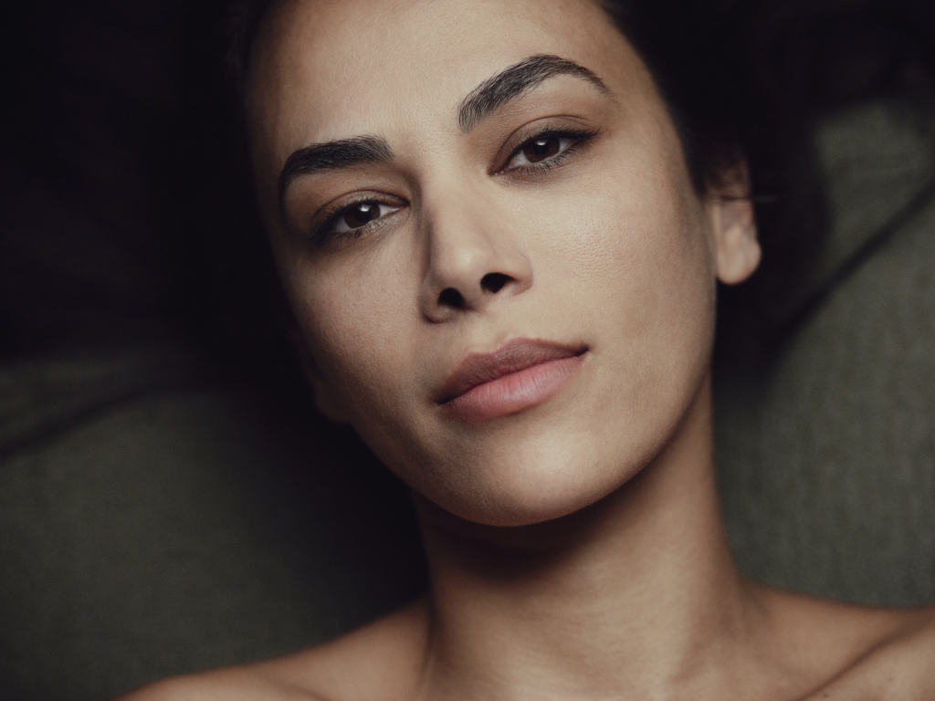 Красивая кареглазая девушка лежит на диване 