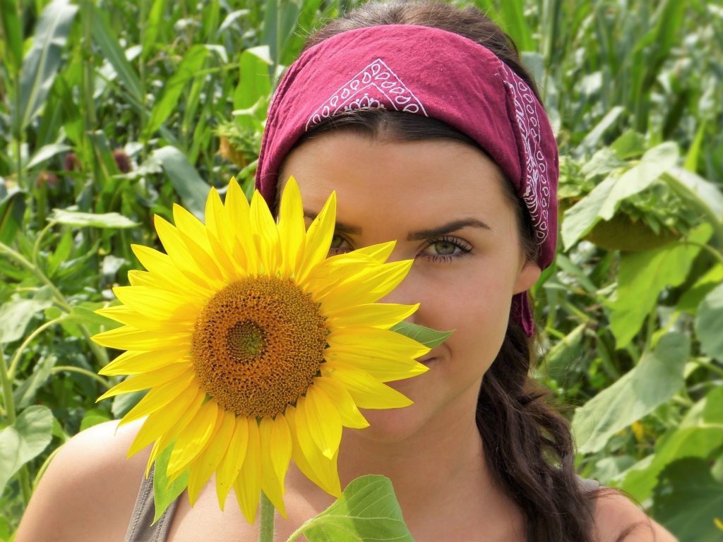 Красивая девушка держит в руках цветок подсолнуха