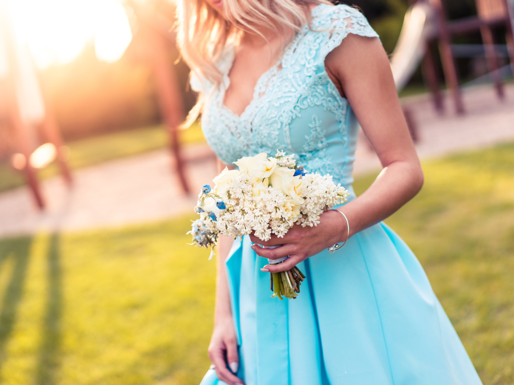 Красивая девушка в голубом платье с букетом в руке