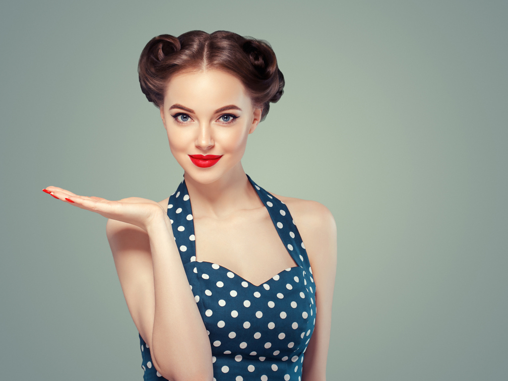 Красивая девушка в платье в горошек на сером фоне