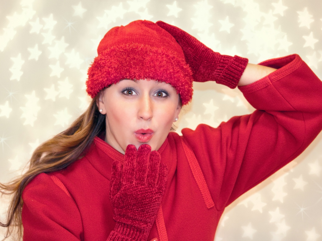 Красивая девушка в красном шлет воздушный поцелуй