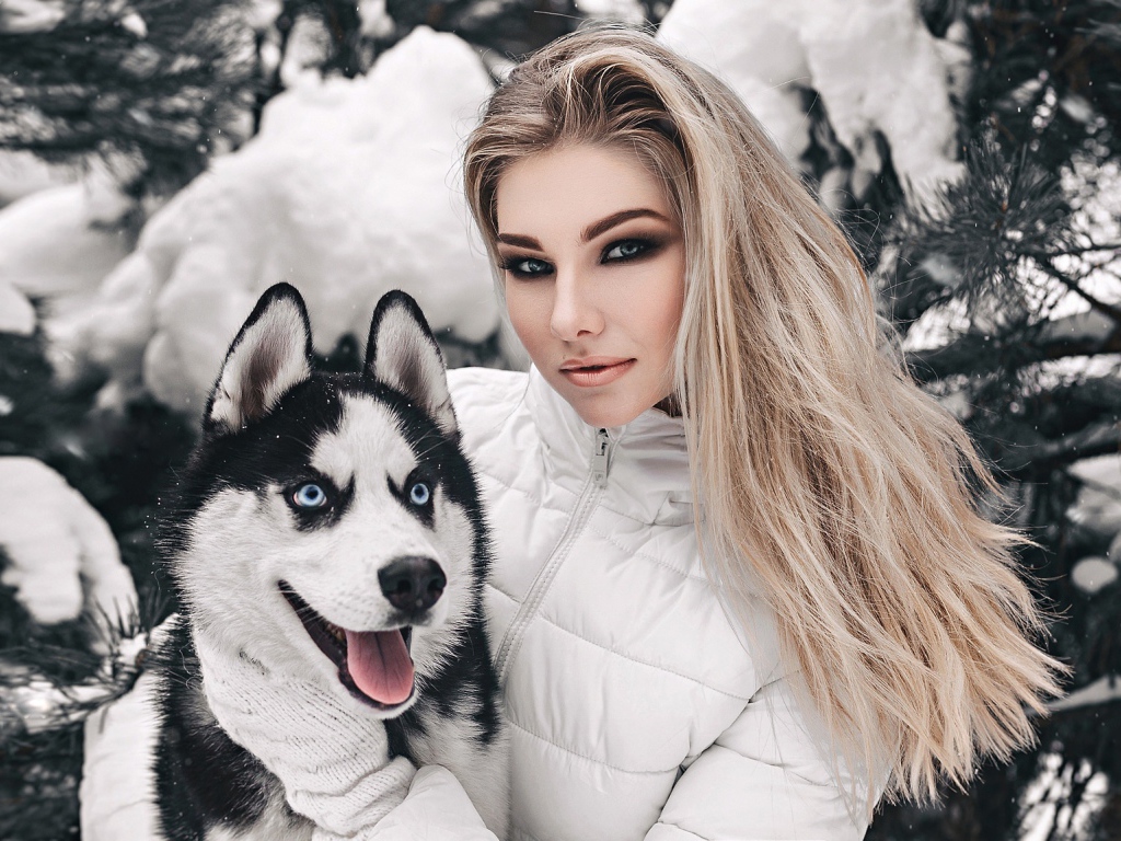 Красивая девушка с хаски у заснеженной ели