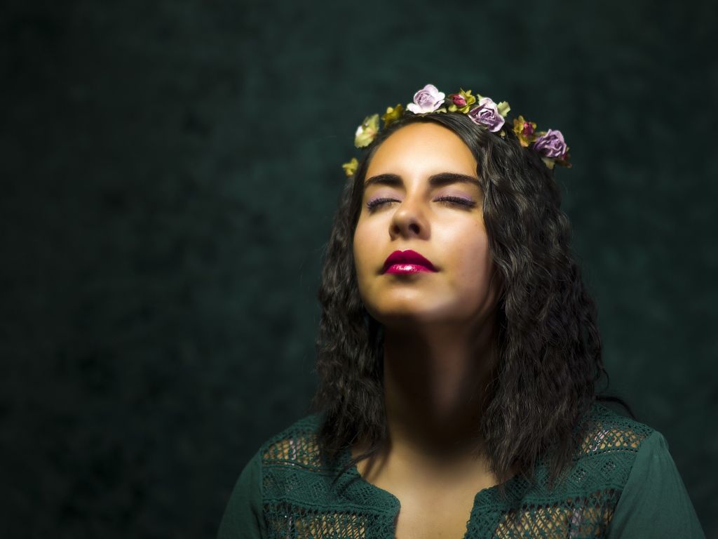 Красивая девушка с закрытыми глазами с венком на голове 