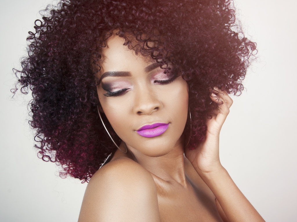 Красивая девушка с кудрявыми волосами  на сером фоне