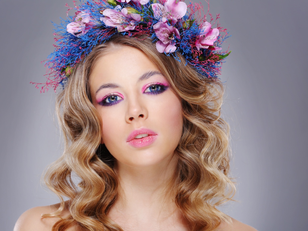 Красивая девушка с нежным макияжем с венком на голове на сером фоне