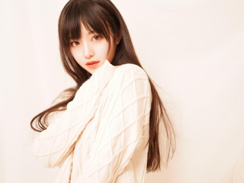 Милая азиатка в белом свитере на розовом фоне