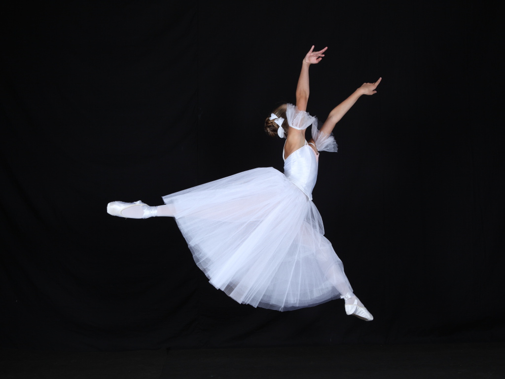 Девушка балерина в белом платье на черном фоне