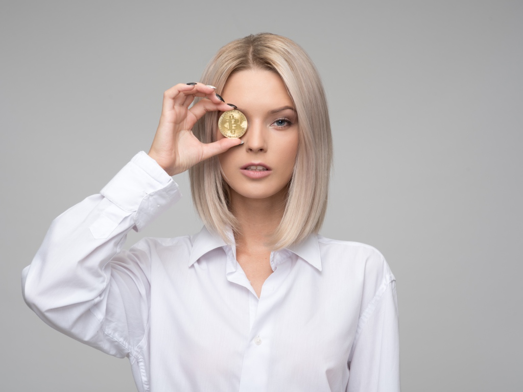 Девушка в белой рубашке с монетой биткоин 