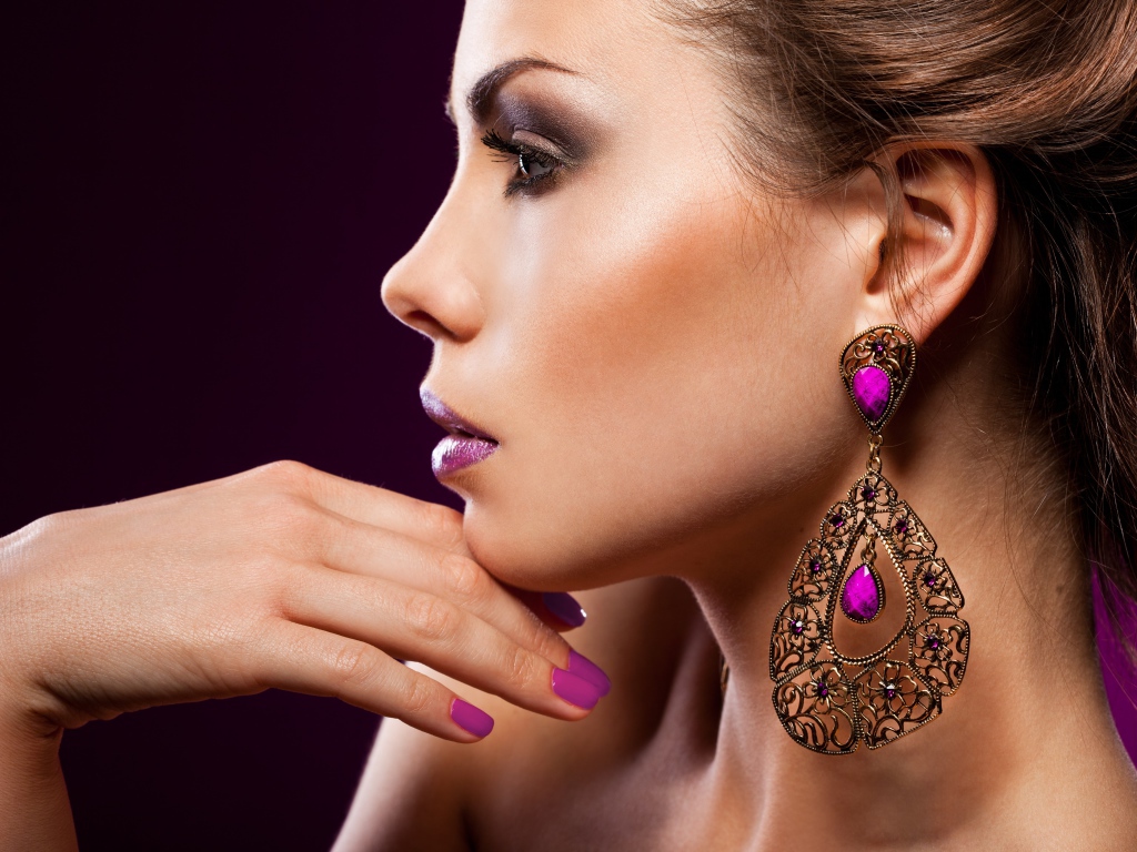 Лицо девушки с красивым макияжем и дорогими серьгами