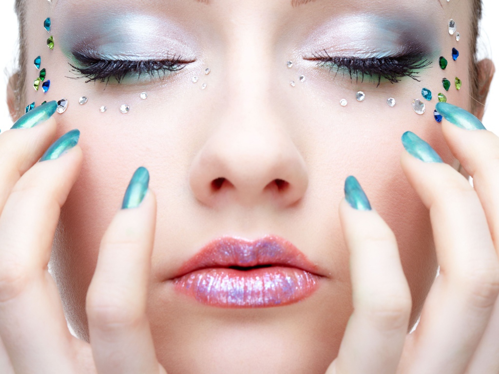 Девушка  с ярким макияжем и стразами на лице 