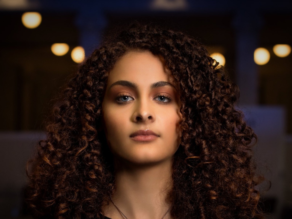 Длинные кудрявые волосы у красивой голубоглазой девушки