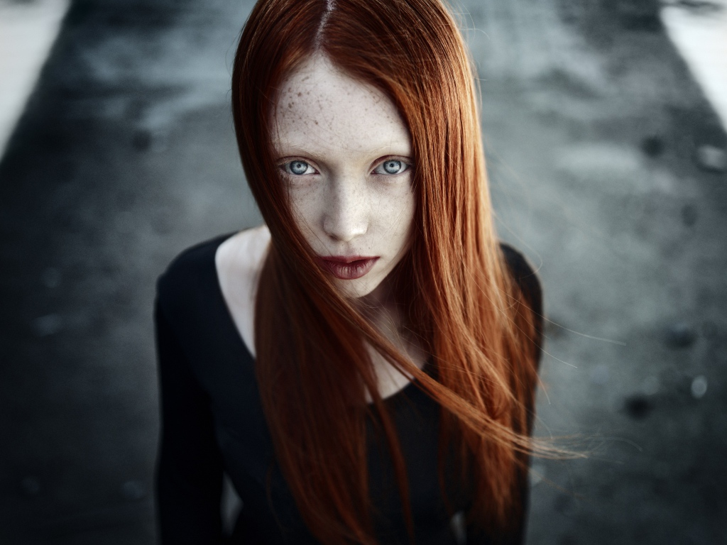 Рыжая длинноволосая девушка с веснушками на лице
