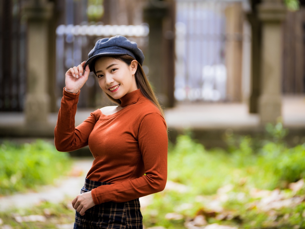 Улыбающаяся девушка азиатка в кепке 