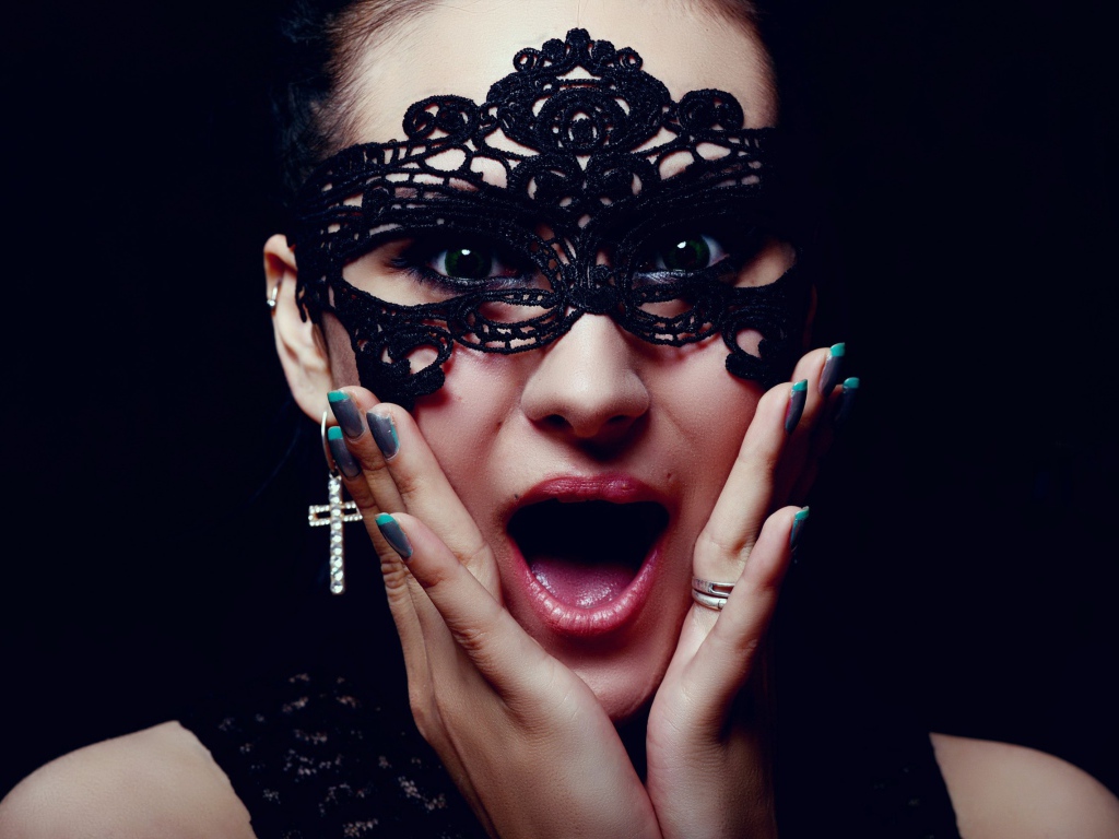 Удивленная девушка в черной маске на лице