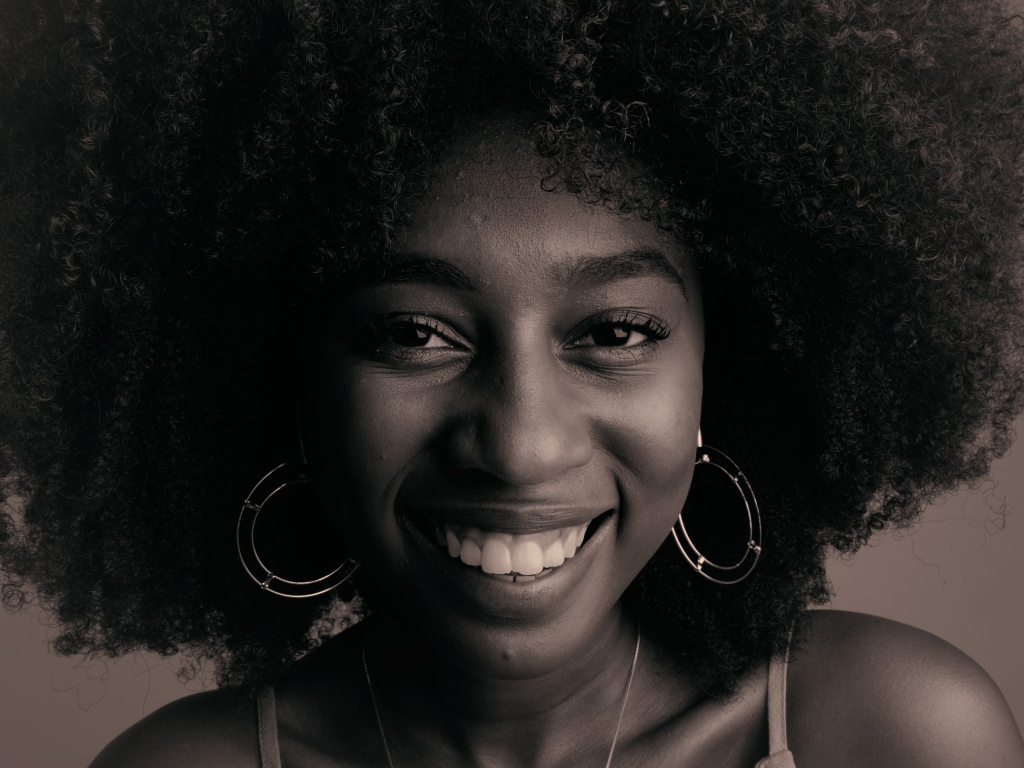 Лицо улыбающейся темнокожей девушки  