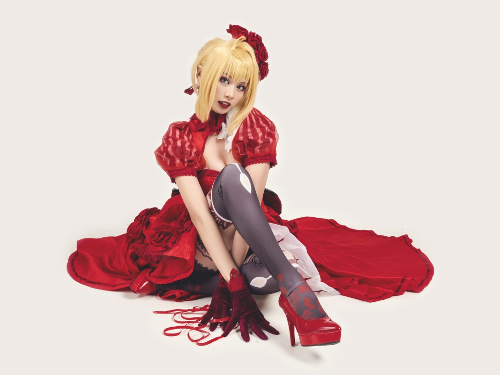 Молодая азиатка в ярком красном костюме на белом фоне