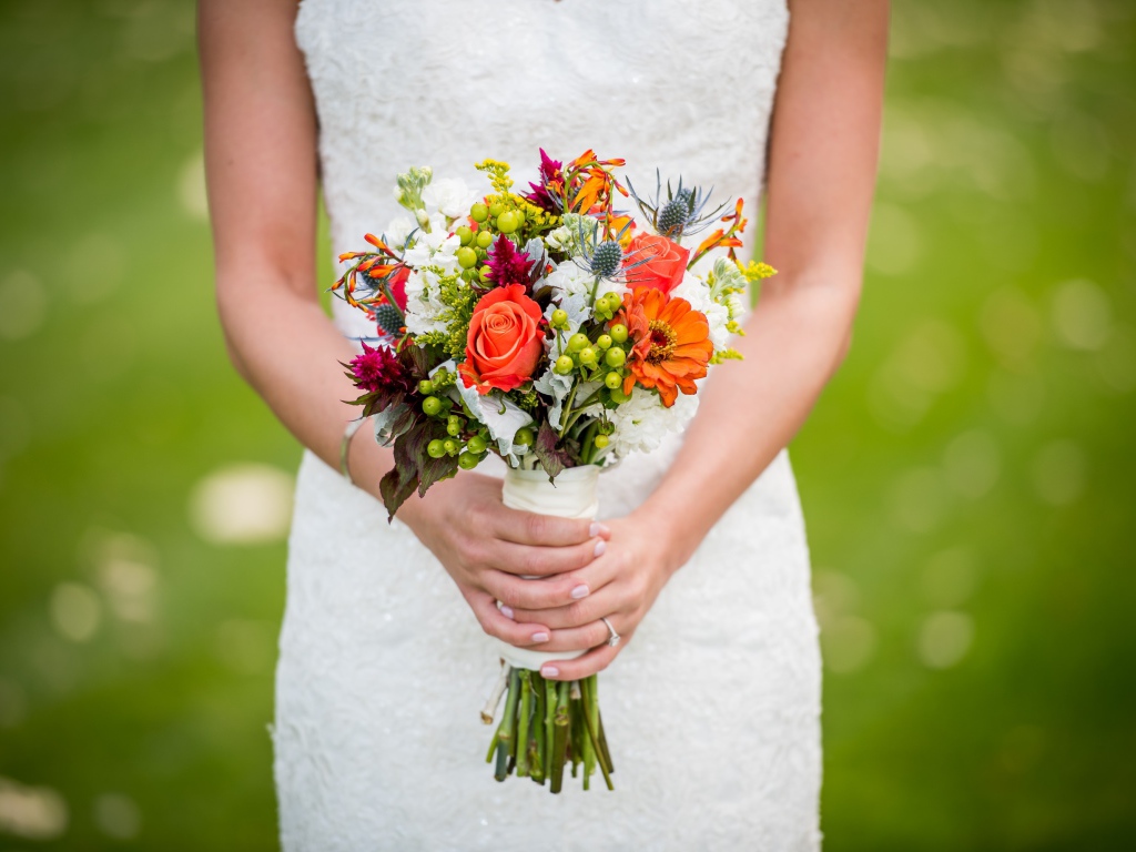 Букет невесты в руках у девушки в белом свадебном платье