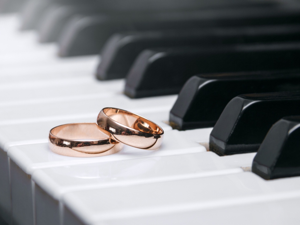 Два золотых обручальных кольца на клавишах рояля 