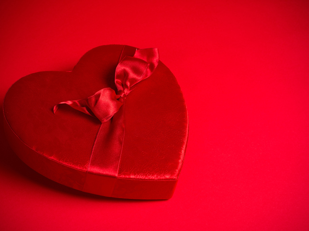 Большое красное сердце с бантом на красном фоне