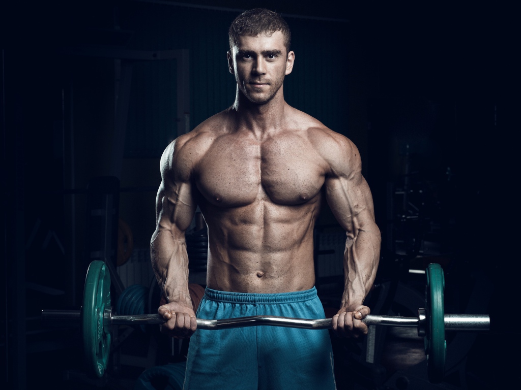 Красивый накаченный мужчина со штангой в руках 