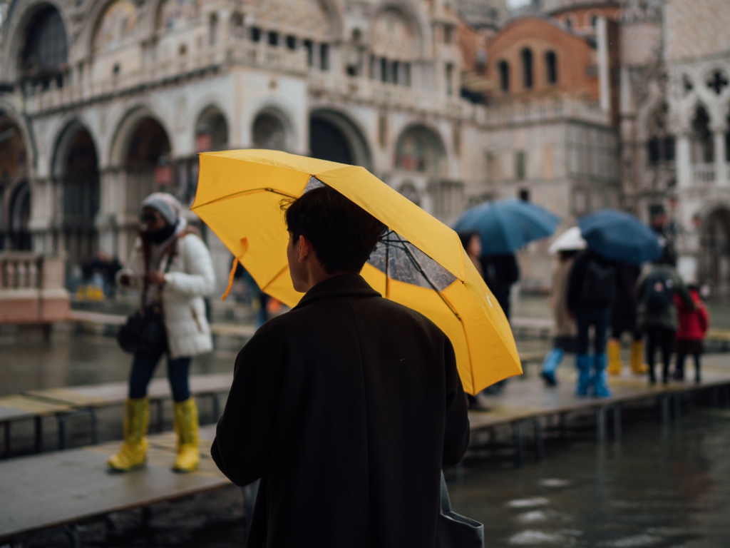 Мужчина с желтым зонтом в городе 