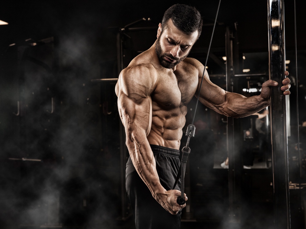 Сильный мужчина бодибилдер в спортзале