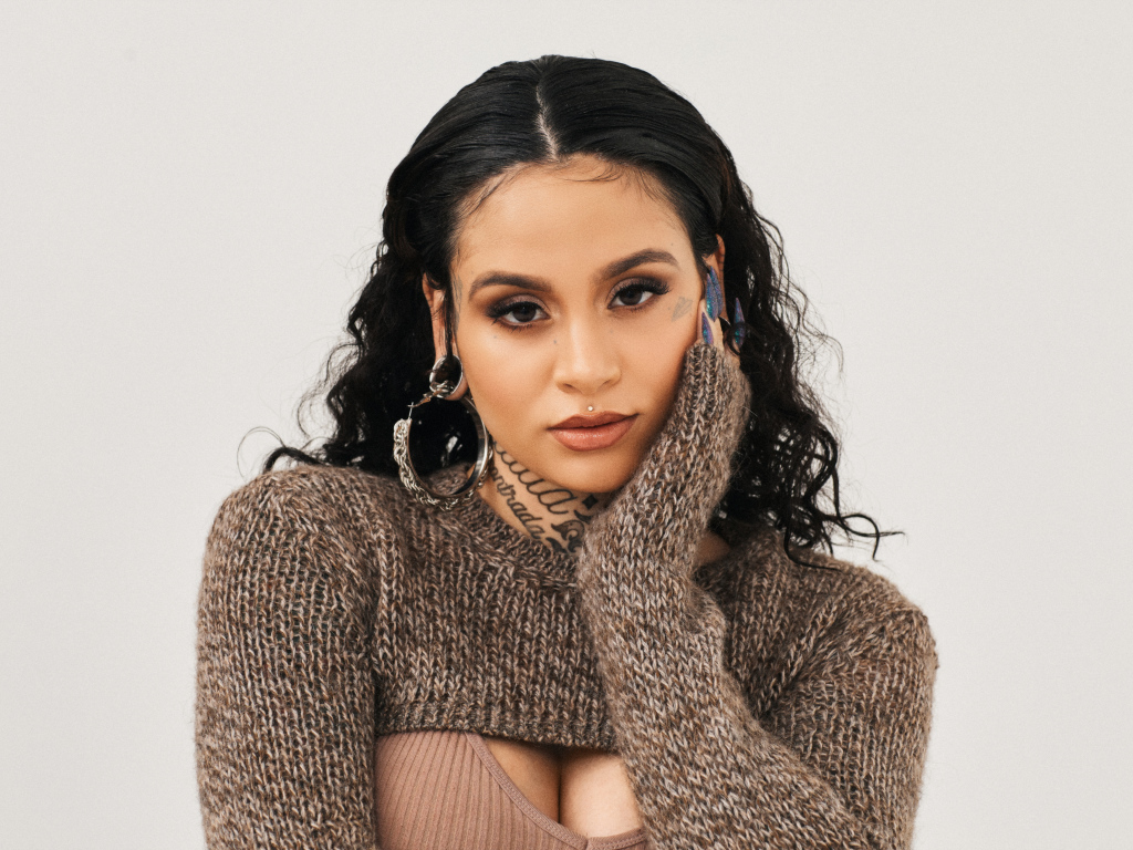 Американская певица Кейлани в свитере на сером фоне