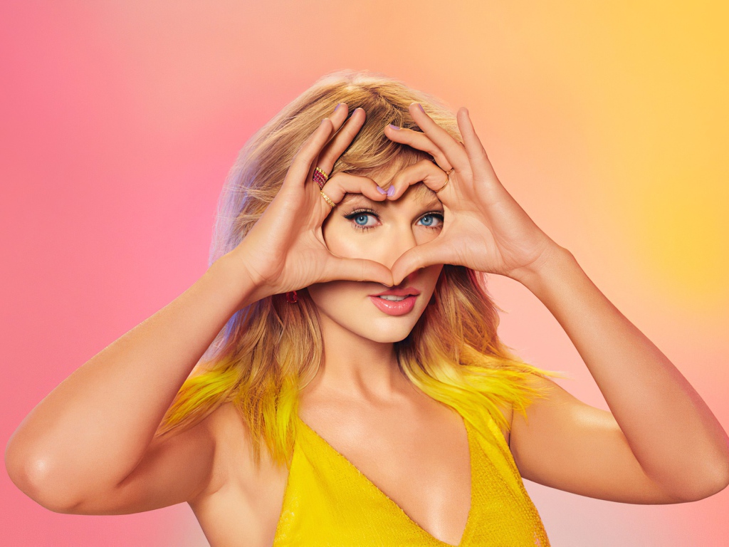 Красивая певица Тейлор Свифт делает сердце из рук на лице