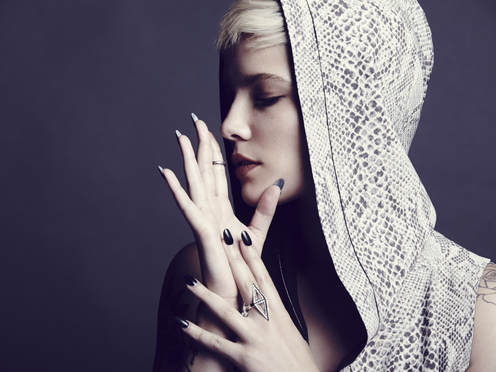 Певица Холзи в капюшоне на сером фоне