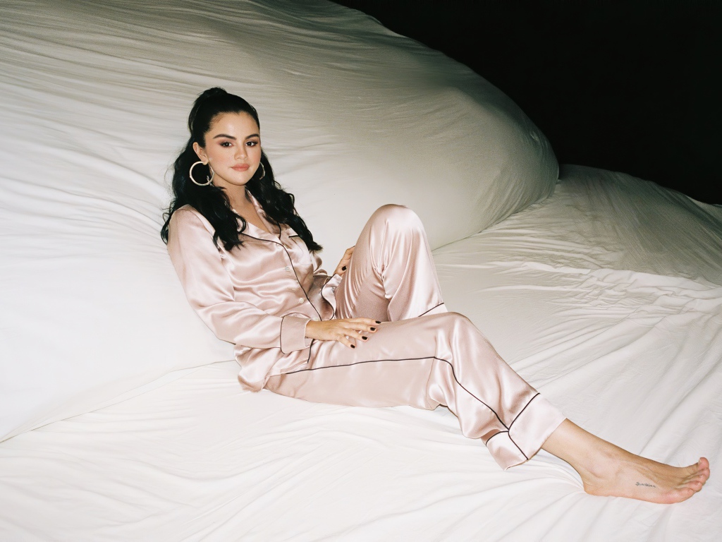Певица Селена Гомез в пижаме на большой белой кровати