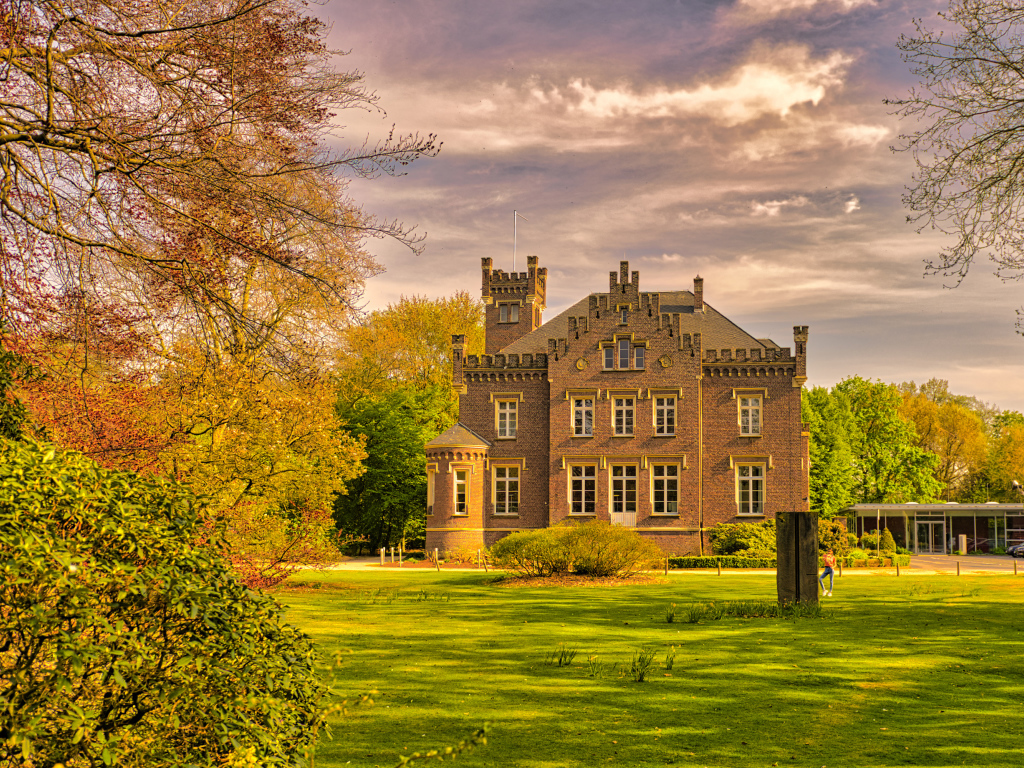 Большой трехэтажный дом в зеленом парке
