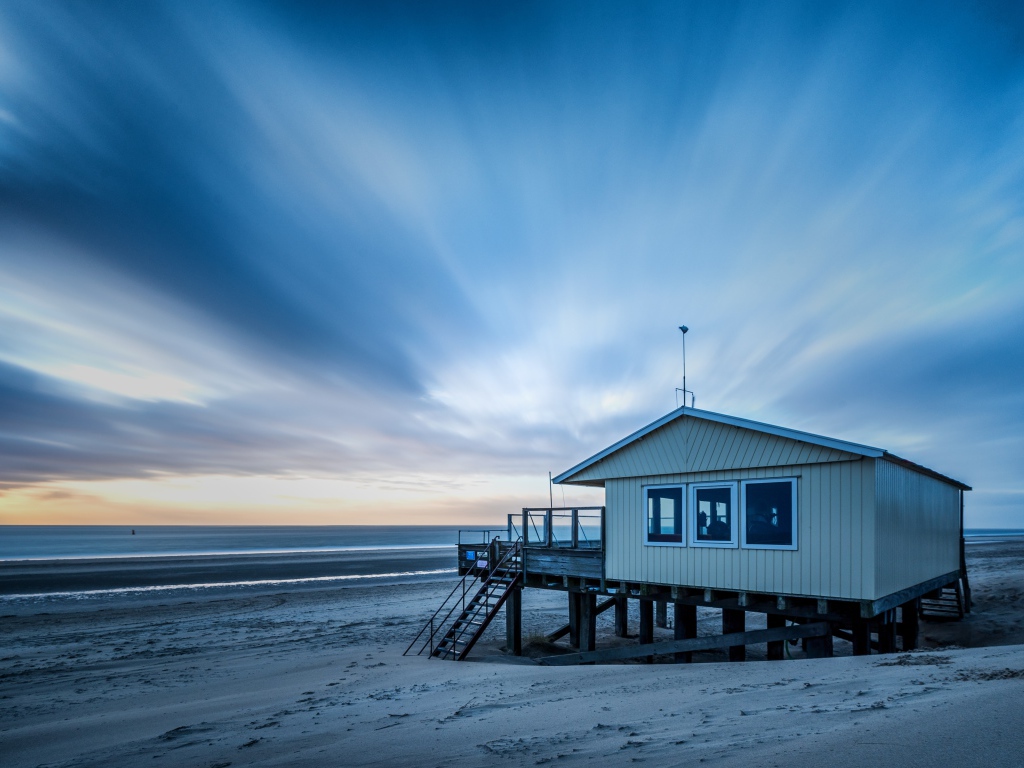 Дом спасателей стоит на пляже под красивым небом