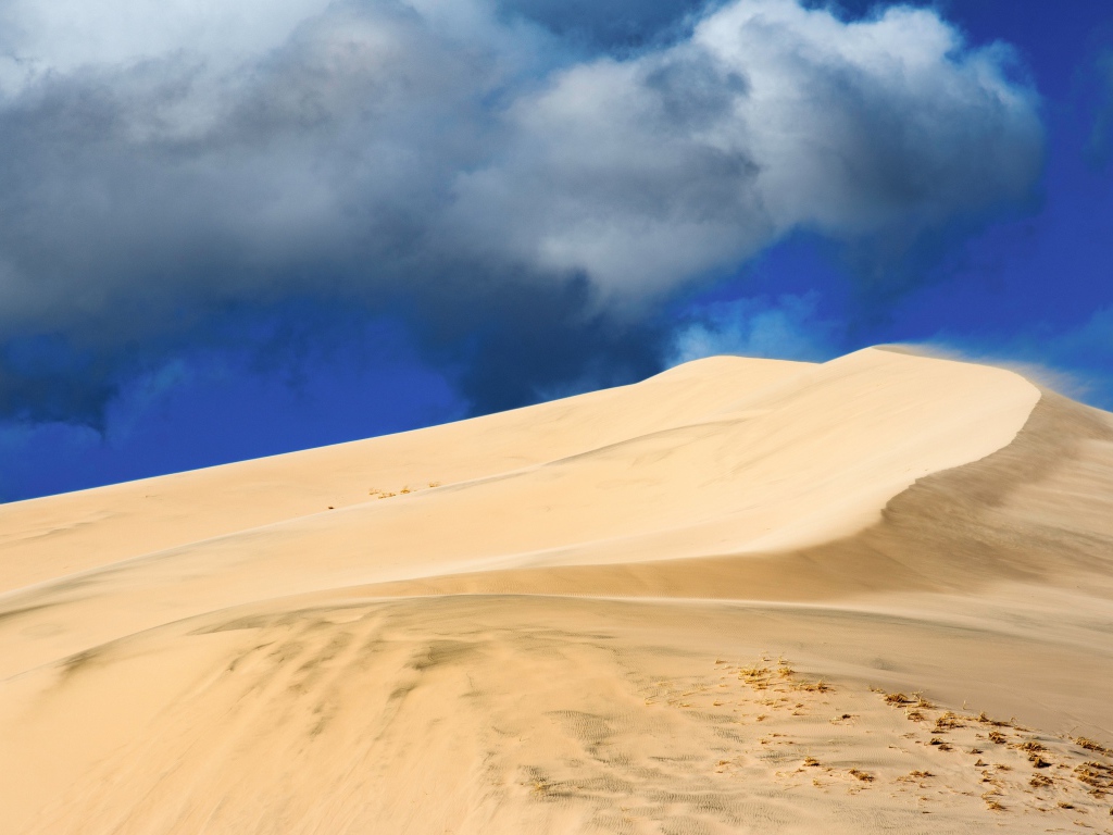 Песчаный бархан под голубым небом