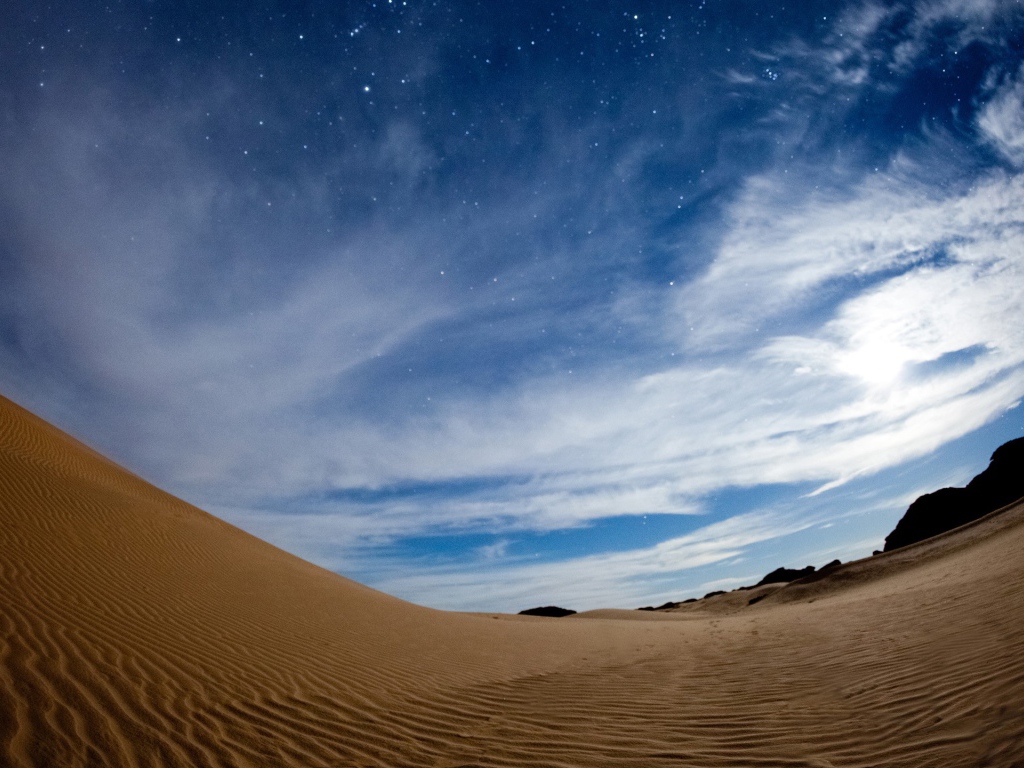 Волнистая песчаная дюна под красивым небом в сумерках 