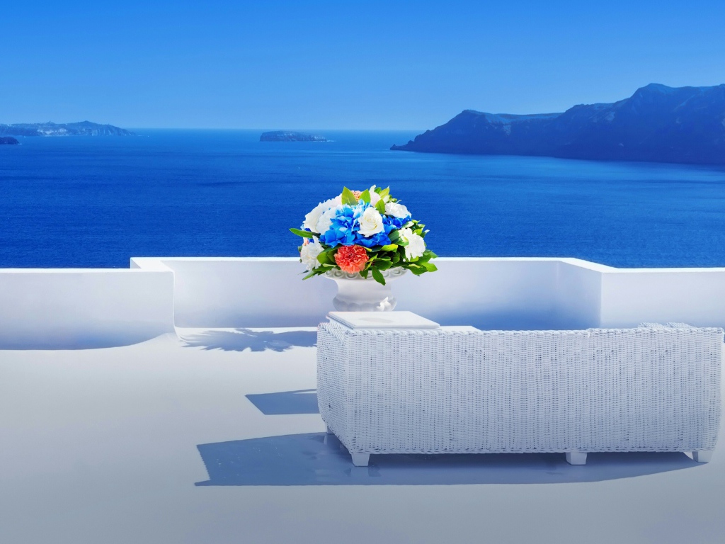 Красивый букет цветов на белом столе на фоне моря