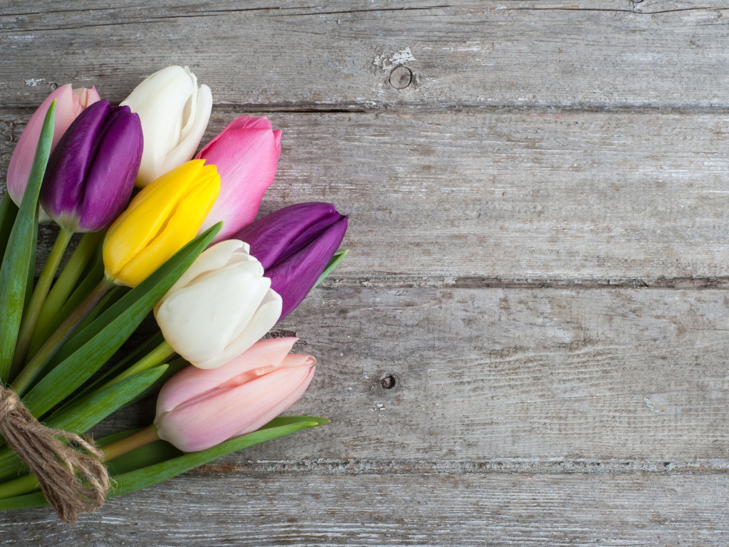 Букет разноцветных тюльпанов на деревянном столе